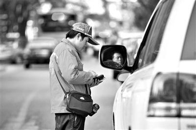 10月15日，朝陽(yáng)區(qū)東大橋路，停車管理員從腰間掏出一個(gè)專用POS機(jī)，正在錄入停車信息。新京報(bào)記者 周崗峰 攝