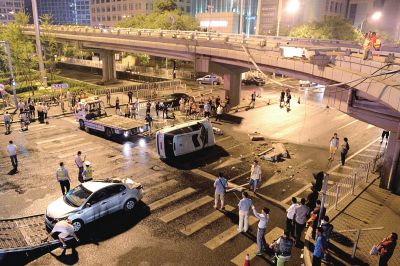 路虎沖下國貿(mào)橋砸中一輛起亞轎車，橋上厚達幾十厘米的水泥護欄被撞斷，碎石四處散落，數(shù)十群眾在現(xiàn)場圍觀。