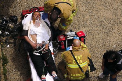 2日，救援人員在美國紐約地鐵事故車輛內緊急疏散一名受傷乘客。圖/CFP